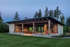 an outdoor living area with stone walls and covered patio, surrounded by trees at dusk