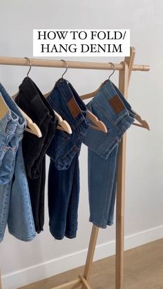 three pairs of jeans hanging on a clothes rack with the words how to fold / hang denim