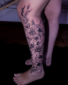 a woman's legs with flowers and leaves on them