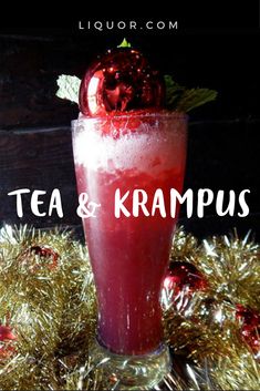 a red drink with an apple on top and the words tea & kramus above it