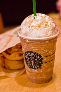 a starbucks drink sitting on top of a wooden table