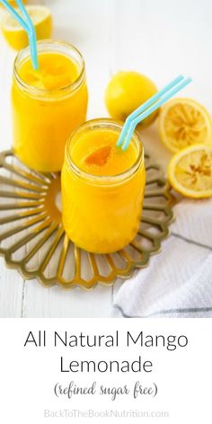 two jars filled with lemonade sitting on top of a table next to sliced lemons