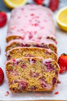 sliced loaf of strawberry lemon pound cake with icing and fresh strawberries on the side