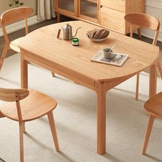 a wooden table with chairs around it and a book on the table next to it