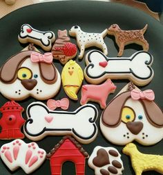 decorated cookies in the shape of dogs and fire hydrants on a black platter