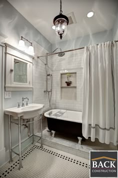 an old fashioned bathtub and sink in a bathroom with black and white floor tiles