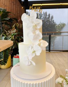 a three tiered cake with white flowers on top