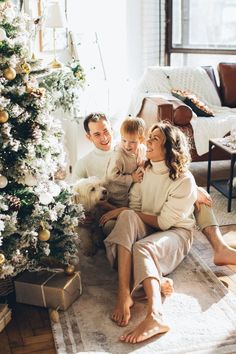 a family sitting in front of a christmas tree