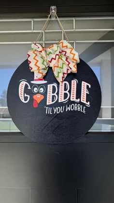 a sign that says gobble til you wobble hanging from the side of a building