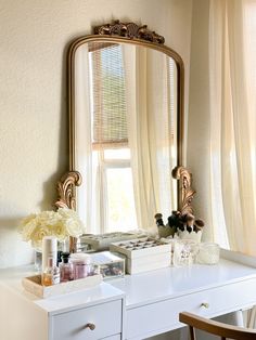 a white desk topped with a mirror and drawers