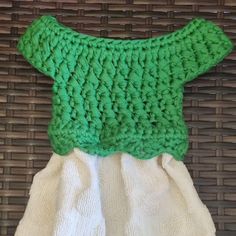 a green and white dress sitting on top of a wicker basket