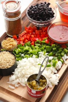 an assortment of ingredients are displayed on a cutting board with spoons and sauces