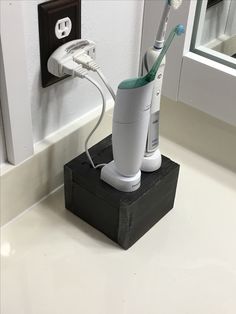 an electric toothbrush holder on a bathroom counter