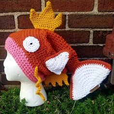 a crocheted hat with a bird on it sitting next to a brick wall