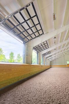 the inside of an empty building with wood flooring and large windows on both sides