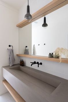 a bathroom with two sinks and hanging lights