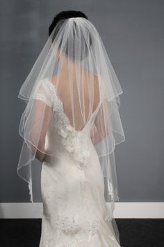 the back of a bride's wedding dress and veil