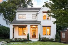 a white house with two story windows in the front yard