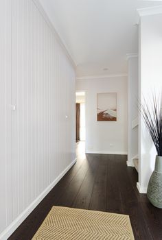 an empty hallway with white walls and wood floors