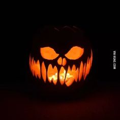 a carved pumpkin with an evil face on it's side and eyes glowing in the dark