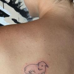 a small elephant tattoo on the back of a woman's shoulder