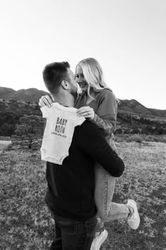 a man and woman kissing in the middle of a field