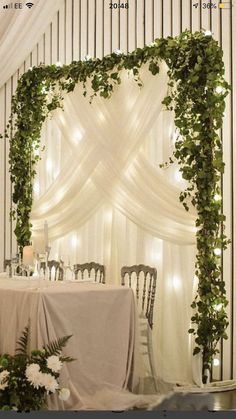 the table is set up with flowers and greenery on it for an elegant wedding