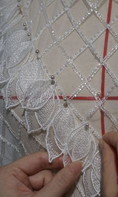 someone is stitching the lace on a dress