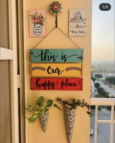 this is our happy place sign hanging on the wall next to potted plants and flowers