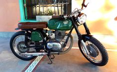 a green motorcycle parked in front of a building