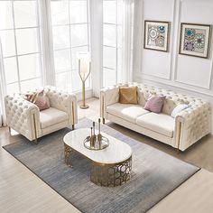 a living room with two couches and a coffee table in front of large windows