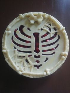 a white plate with red and black designs on the front is sitting on a table