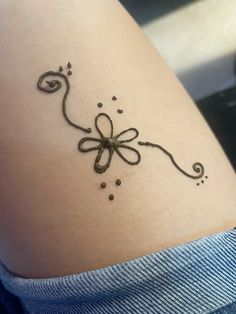 a tattoo design on the back of a woman's thigh, with swirls and dots