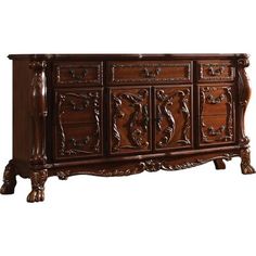 an ornately carved wooden sideboard with drawers and carvings on the front, in dark wood