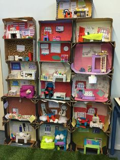 a room filled with lots of doll houses and toys on shelves next to a green carpet