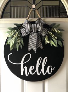 a black and white door hanger with the word hello written on it in front of a wreath