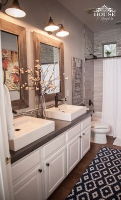 a bathroom with double sinks and two mirrors on the wall next to a shower curtain