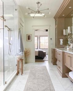 a large bathroom with white tile floors and wooden cabinets, along with an area rug on the floor