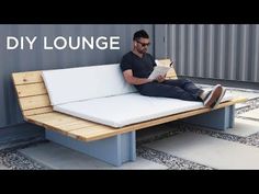 a man sitting on a bench reading a book with the words diy lounge in front of him