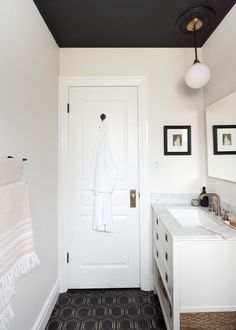 a bathroom with a white door and black ceiling