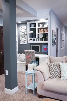 the living room is decorated in shades of gray and white, with pops of color