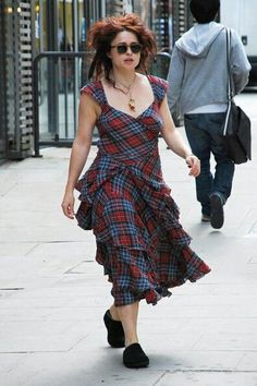 a woman walking down the street in a dress