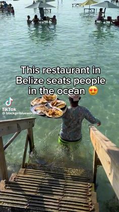 a man standing in the water holding a plate of food