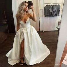 a woman taking a selfie in a white dress with her legs slited up