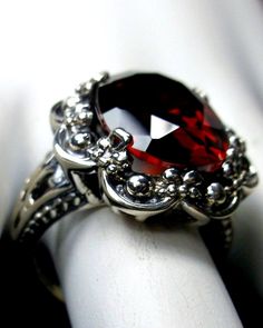 Red Garnet Cubic Zirconia Ring Bouquet Design#118 Custom Made This is a beautiful vintage inspired sterling silver filigree 12 carat red garnet cubic zirconia (CZ) gemstone ring. The high quality oval full cut gemstone is 19mm (3/4") by 14mm (9/16"). The inside of the band is marked 925 for sterling silver. Call it vintage or gothic, this is an amazing reproduction of an antique ring. There is beautiful filigree with sweet swirls and a bouquet-like design throughout the silver setting. This dazz Ring Bouquet, Vampire Aesthetics, Silver Bouquet, Vampire Ring, Bouquet Ring, Daughter Ring, Weird Jewelry, Celtic Ring, Historical Jewellery