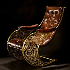 a brown leather rocking chair sitting on top of a black floor