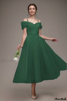 a woman in a green dress holding flowers