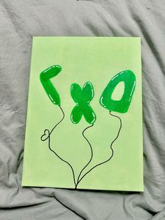 a green piece of paper with the number nine drawn on it and balloons in the shape of numbers