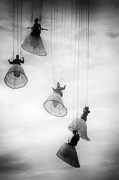 four people are suspended from the sky by parachutes