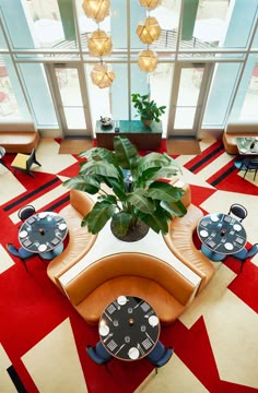 a living room filled with lots of furniture and a potted plant in the center